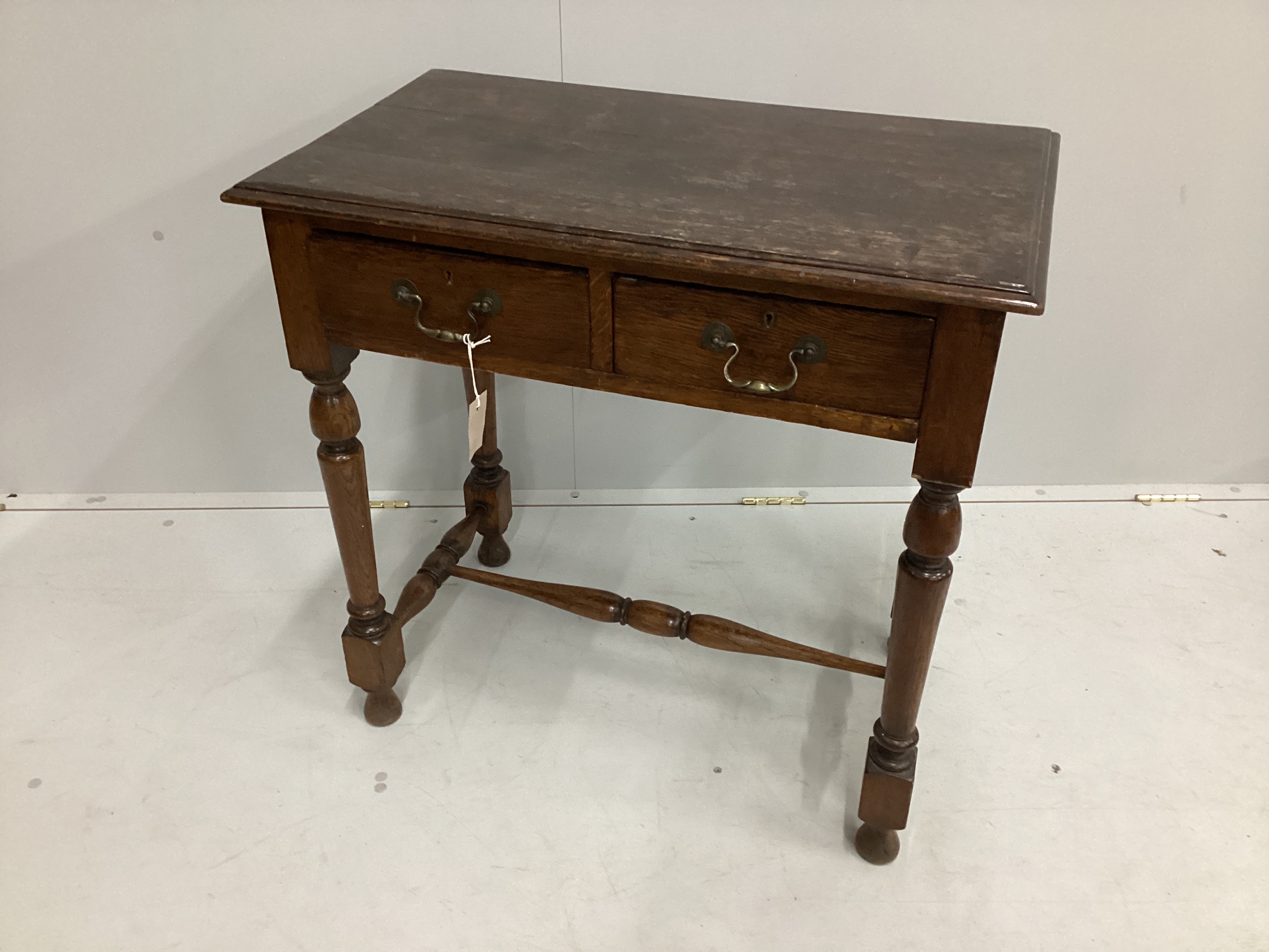 An early 20th century oak two drawer side table, width 76cm, depth 44cm, height 76cm